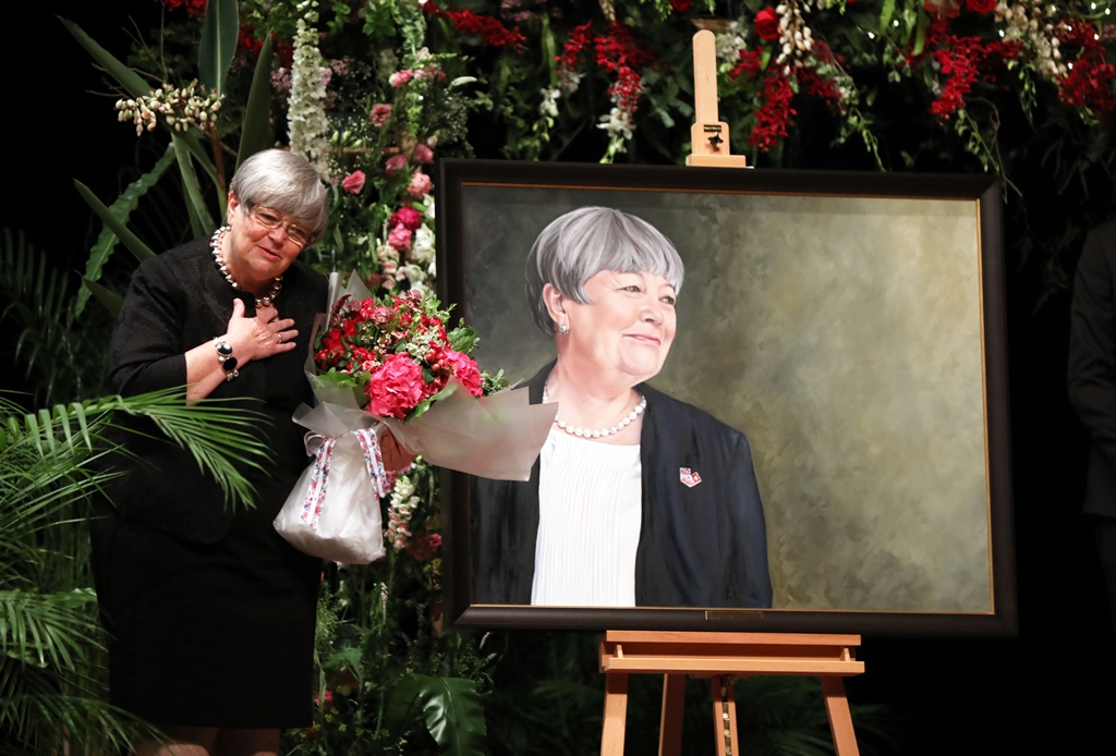 photo of woman on stage accepting flowers